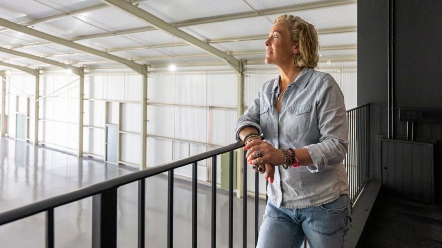 Presenter Sarah Beeny looking out from a gallery into a studio space