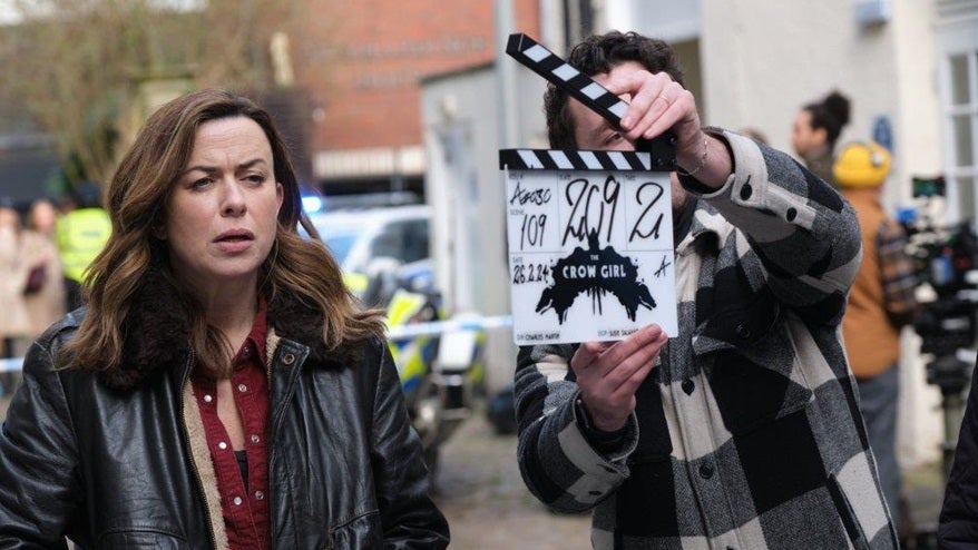 Actor Eve Myles in Paramount Plus drama The Crow Girl, filming in Bristol in leather jacket with clapperboard behind her 
