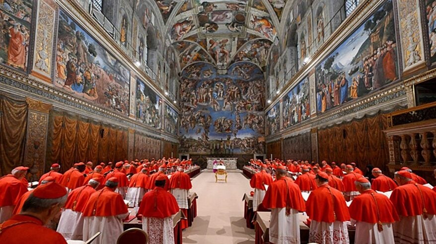 A group of cardinals stand in the Vatican's elaborate Sistine Chapel